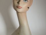 une tête de mannequin posée sur une table blanche