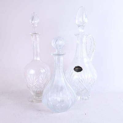trois vases en verre posés l'un à côté de l'autre sur une surface blanche