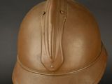 a brown helmet on a stand on a black background