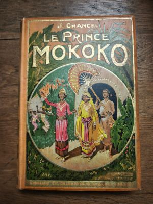an old book on a wooden table with a picture of a woman holding a parasol
