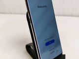a close up of a cell phone on a stand on a white surface