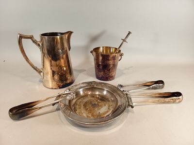 a lot of silverware sitting on a white table