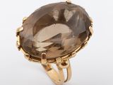 un gros plan d'une bague en or sertie d'un gros quartz fumé