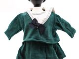 un mannequin vêtu d'une robe verte et d'un chapeau