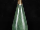 un gros plan d'un pendentif en jade vert en forme de larme sur fond noir