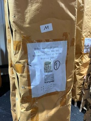 un sac sur lequel est accrochée une pancarte, posé par terre