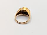 a close up of a gold ring on a white surface