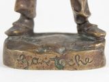 bronze figurine of a man holding a baseball bat on a base