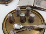 a plate with silver spoons and other silverware on it