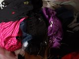 a pile of clothes sitting on top of a bed