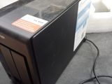 a small black computer on a table with a box in the background