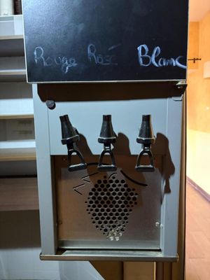une photo d'un distributeur de boissons gazeuses sur lequel est accrochée une ardoise