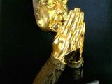 statue en or représentant une personne en prière, les mains jointes