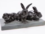sculpture of three rabbits sitting on a marble base