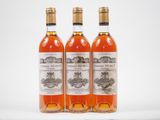 trois bouteilles de vin posées les unes à côté des autres sur une surface blanche