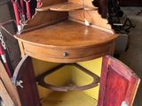 une armoire d'angle en bois surmontée d'un miroir