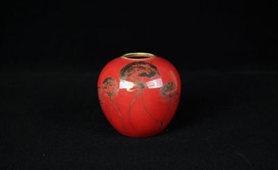 un vase rouge sur lequel est représentée une femme