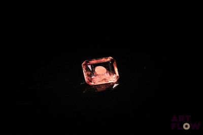 un losange orange dans l'obscurité, sur fond noir