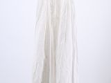 the white dress is hanging on a hanger against a wall