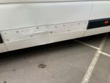 a white bus that has bullet holes on the side of it