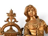 a gold statue of a woman holding a basket