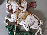 a statue of a man riding a horse with a dragon