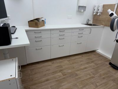 an image of a kitchen with white cabinets and wood flooring