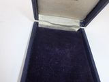 a small black box with a gold ring inside of it
