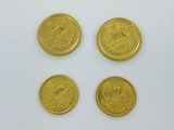 four gold coins on a white surface with a white background