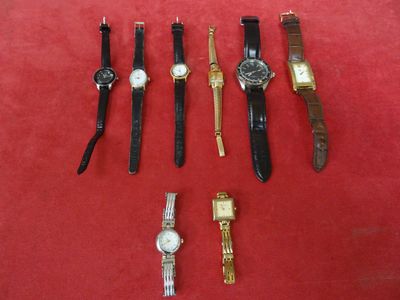 a lot of watches that are sitting on a red surface