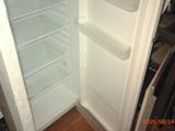 an open refrigerator in the corner of a kitchen