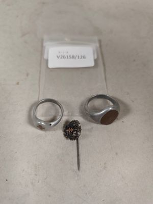 deux bagues et une paire de boucles d'oreilles posées sur une table
