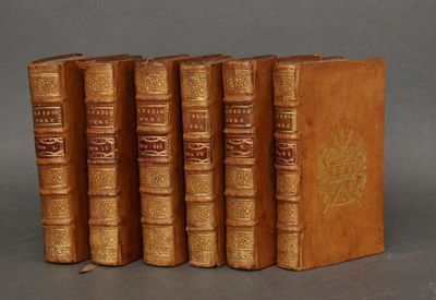 quatre vieux livres sont alignés les uns à côté des autres sur une surface grise