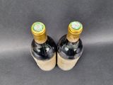 two bottles of wine sitting on top of a black surface