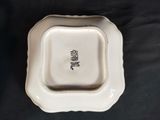 a white plate with a square shaped design on it