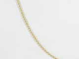 a gold necklace with a twisted rope on a white background