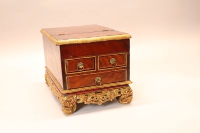 a small chest of drawers on a stand on a white surface