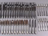 a lot of silverware on a table with a knife and fork