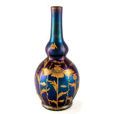 un vase bleu et or orné d'un motif floral