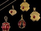 four gold and enamel ladybug pendants and a gold chain