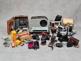 beaucoup de vieux appareils photo et d'autres objets sur la table