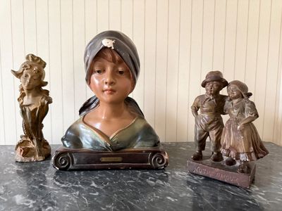 three figurines of a woman and a man on a table