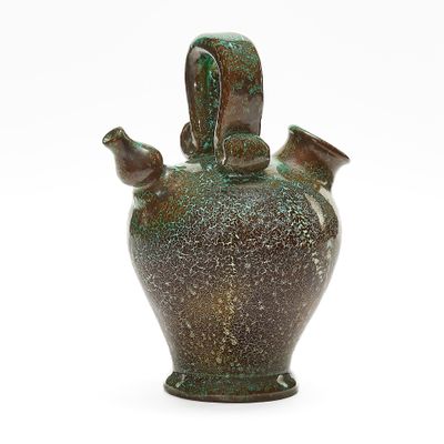 a green vase that is sitting on a white surface