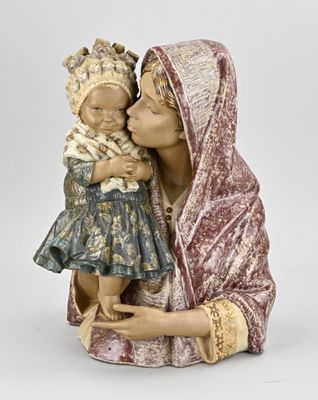 figurine d'une femme tenant un bébé dans ses bras