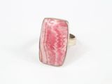 gros plan d'une bague en pierre rose sur une surface blanche