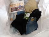 a bag of clothing and a book on a bed