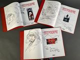 three books with drawings of people on them sitting on top of a table