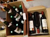 plusieurs bouteilles de vin dans un carton posé sur le sol