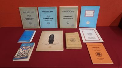 plusieurs livres posés sur une table recouverte d'une nappe rouge, devant un mur rouge