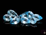 three blue topazte diamonds on a black surface